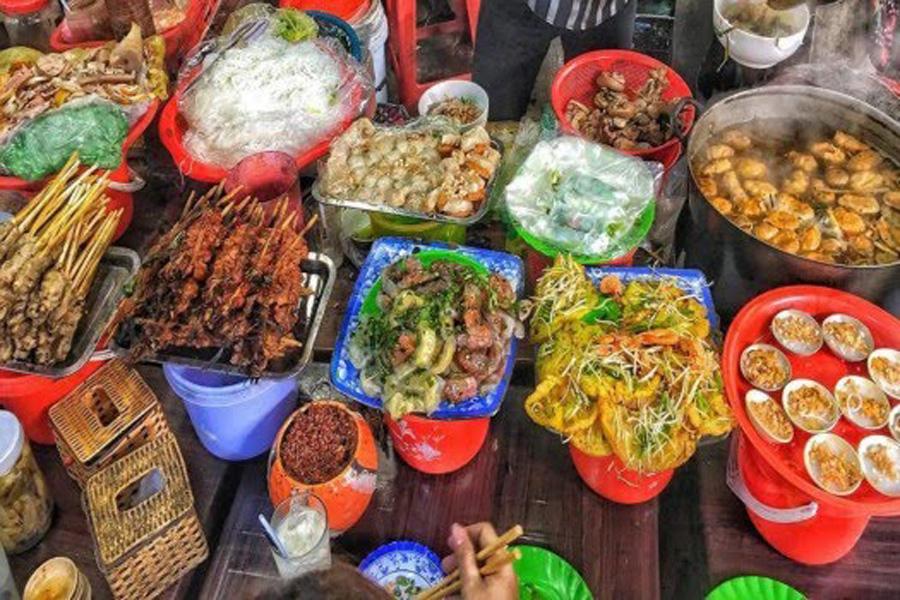 Du khách thưởng thức các món ăn đặc sản tại khu ẩm thực chợ Đông Ba. Đây là điểm đến hấp dẫn để khám phá tinh hoa ẩm thực truyền thống của Huế.