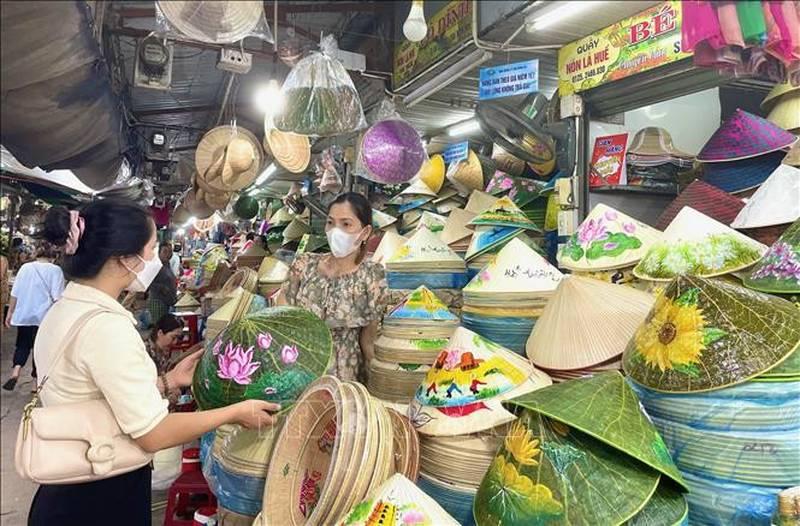 Gian hàng bày bán đặc sản Huế và quà lưu niệm tại chợ Đông Ba với nhiều sản phẩm truyền thống như mè xửng, tôm chua, mắm Huế và nón lá.