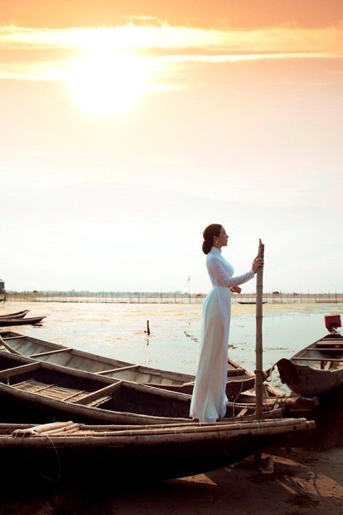 Du khách mặc áo dài truyền thống và đội nón lá chụp ảnh tại phá Tam Giang. Khung cảnh đầm phá rộng lớn cùng ánh sáng tự nhiên tạo nên bộ ảnh mang đậm bản sắc văn hóa Huế.