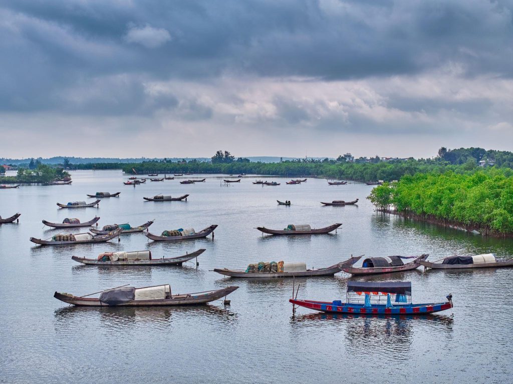 Hình ảnh đầm phá Tam Giang, Huế với những chiếc thuyền đánh cá, rừng ngập mặn và mặt nước rộng lớn, mang đến vẻ đẹp bình yên đặc trưng của vùng đầm phá.