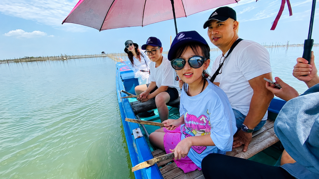 Hình ảnh gia đình vui vẻ chụp ảnh tại phá Tam Giang, Huế. Không gian rộng rãi, phong cảnh đẹp cùng các hoạt động trải nghiệm nhẹ nhàng khiến nơi đây trở thành lựa chọn lý tưởng cho kỳ nghỉ của nhiều thế hệ trong gia đình.